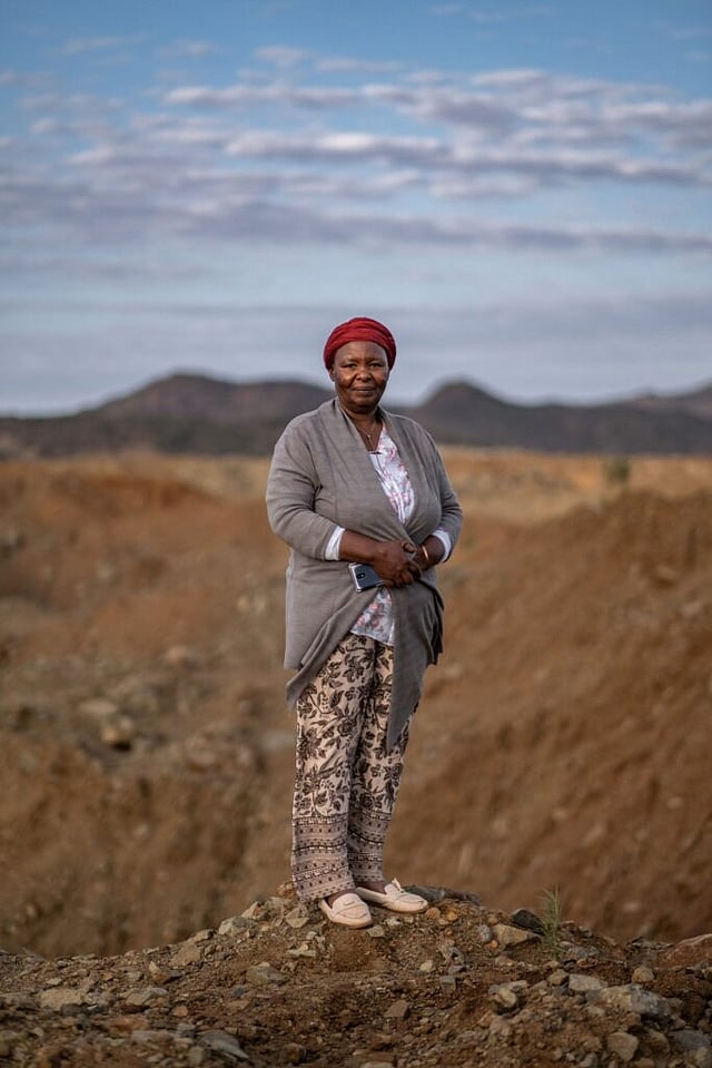 Community member standing near a rural mining area